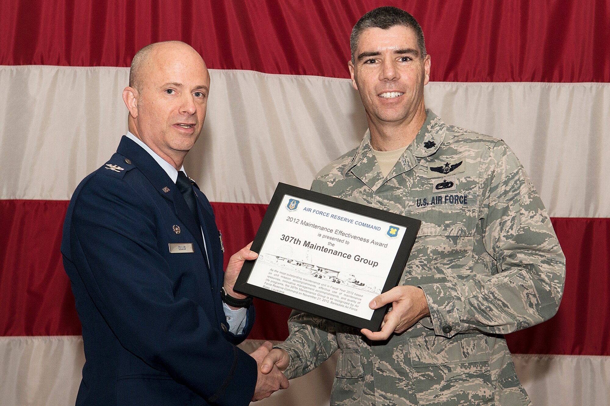 U.S. Air Force Col. Jonathan Ellis, 307th Bomb Wing commander, presents the Maintenance Effectiveness Award to Lt. Col. Kenneth Rose, 307th Maintenance Group commander, during a Commander's Call, Mar. 3, 2013, Barksdale Air Force Base, La. The group was recognized by the Air Force Reserve Command as the most outstanding maintenance unit in Fiscal Year 2012 based on unit mission accomplishments, effective use of maintenance resources, innovative management accomplishments, and quality of life programs. (U.S. Air Force photo by Master Sgt. Greg Steele/Released)