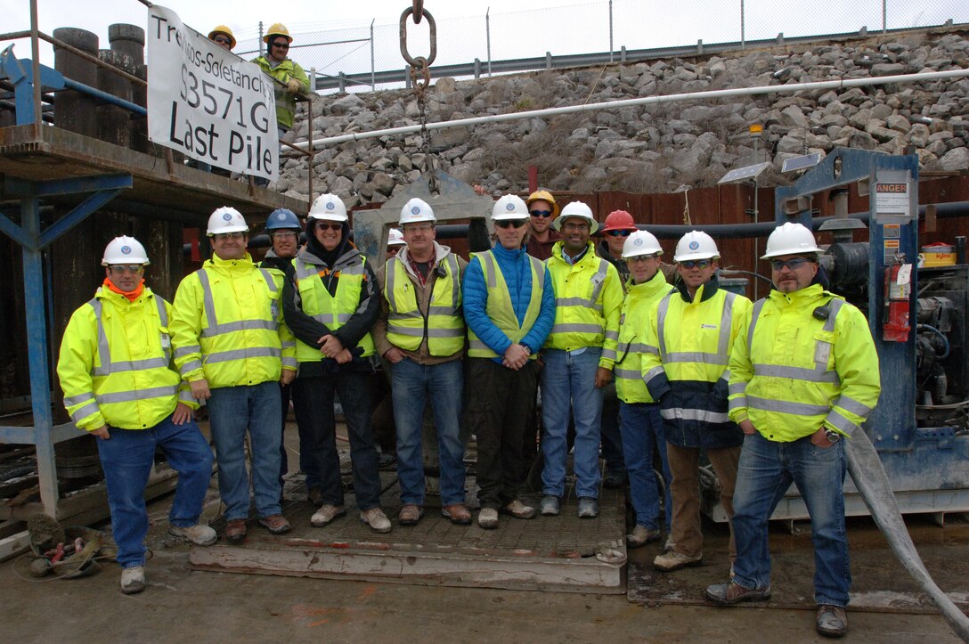 Team members from Treviicos-Soletanche Joint Venture, contractor for the Wolf Creek Dam Foundation Remediation Project, pose March 6, 2013 as they celebrate completing the barrier wall that is made up of nearly 300,000 cubic yards of concrete.  The U.S. Army Corps of Engineers Nashville District project is designed to stop seepage through the karst geology deep in the foundation of the dam's 4,000-foot long embankment. (USACE photo by Lee Roberts)