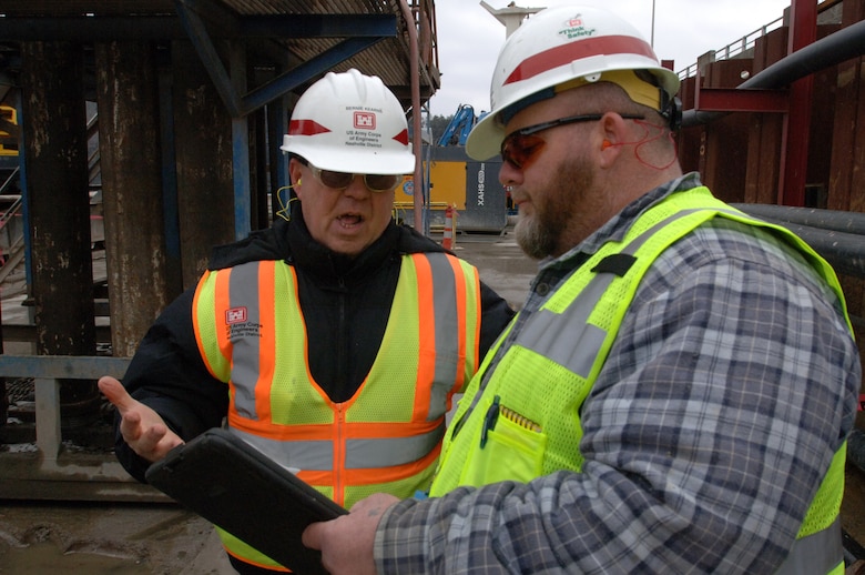 Andy Gruver (Right), U.S. Army Corps of Engineers Nashville District construction representative, and Bernie Kearns, materials engineering technician, monitor the placement of concrete March 6, 2013 for the last pile in the barrier wall at Wolf Creek Dam in Jamestown, Ky. (USACE photo by Lee Roberts)