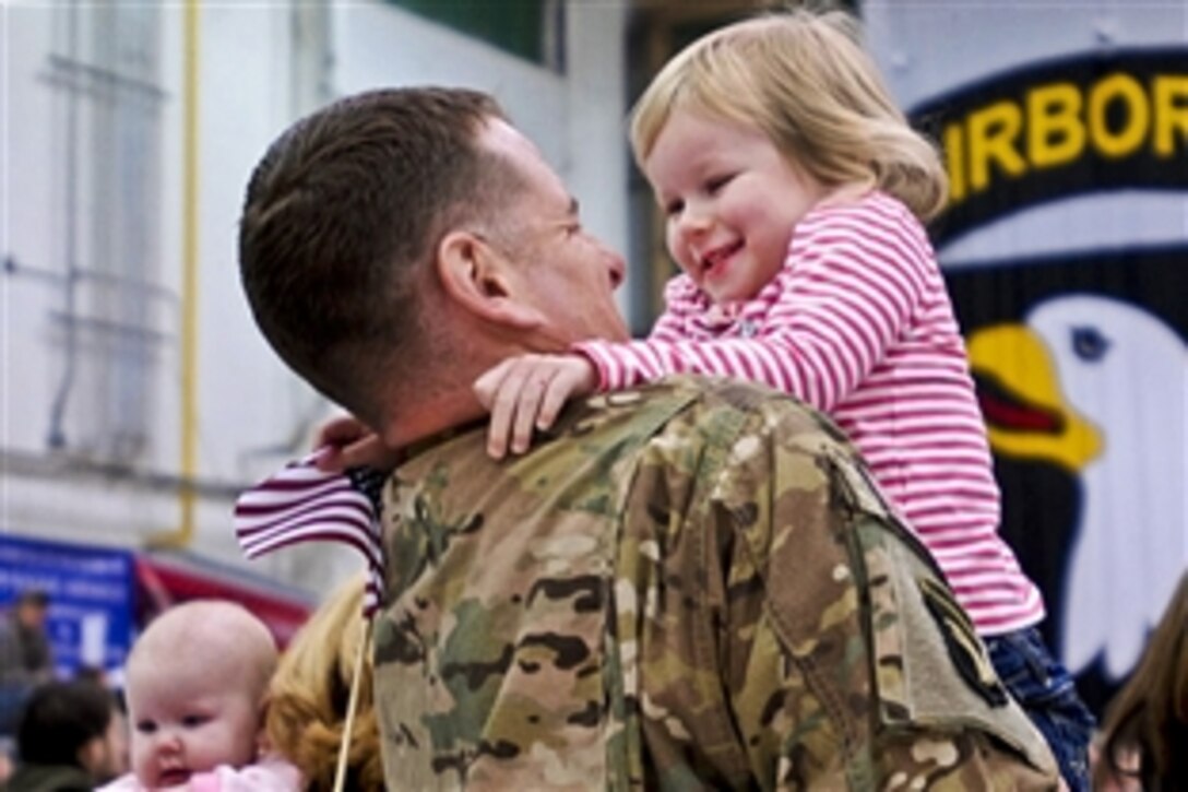 An Army soldier embraces his daughter while being recognized at a welcome home ceremony on Fort Campbell Army Airfield, March 1, 2013, when he returned from a deployment to Afghanistan. He and soldiers in his unit returned after about six months rather than the full nine months due to the progress of Afghan forces, which are conducting operations independently. 