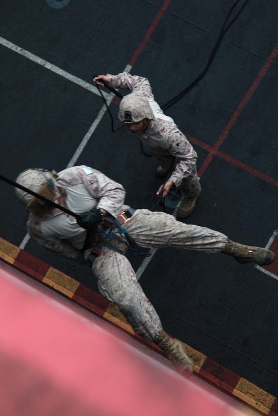 A Marine with the 15th Marine Expeditionary Unit rappels off the flight deck of USS Peleliu, March 5.  The main training objective was keeping the 14 BLT Helicopter Rope Suspension Technique masters current in their qualifications, but it also gave the Security Platoon an opportunity to practice rappelling, which is one of the ways troops can be inserted into different situations.  The 15th MEU is deployed as part of the Peleliu Amphibious Ready Group as a U.S. Central Command theater reserve force, providing support for maritime security operations and theater security cooperation efforts in the U.S. 5th Fleet area of responsibility. (U.S. Marine Corps photo by Cpl. John Robbart III)