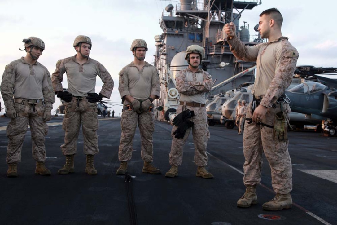 Sergeant Scott W. Gilchrist, recovery team leader, 81mm Mortars/Tactical Recovery of Aircraft and Personnel Platoon, Weapons Company, Battalion Landing Team 3/5, 15th Marine Expeditionary Unit, explains rappelling techniques to Marines during training off the flight deck of the USS Peleliu, March 5.  The main training objective was keeping the 14 BLT Helicopter Rope Suspension Technique masters current in their qualifications, but it also gave the Security Platoon an opportunity to practice rappelling, which is one of the ways troops can be inserted into different situations. The 15th MEU is deployed as part of the Peleliu Amphibious Ready Group as a U.S. Central Command theater reserve force, providing support for maritime security operations and theater security cooperation efforts in the U.S. 5th Fleet area of responsibility. Gilchrist, 24, is from Hurst, Texas, and is a HRST master with the unit. (U.S. Marine Corps photo by Cpl. John Robbart III)