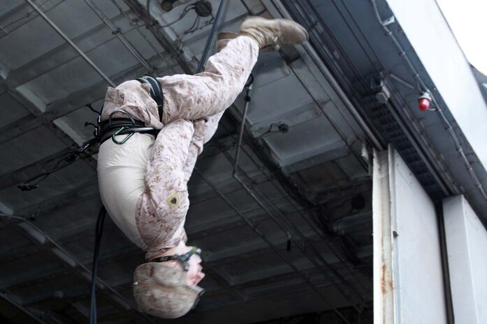 Sergeant Scott W. Gilchrist, recovery team leader, 81mm Mortars/Tactical Recovery of Aircraft and Personnel Platoon, Weapons Company, Battalion Landing Team 3/5, 15th Marine Expeditionary Unit, practices a carabineer tie-off during rappelling training off the flight deck of USS Peleliu, March 5.  The main training objective was keeping the 14 BLT Helicopter Rope Suspension Technique masters current in their qualifications, but it also gave the Security Platoon an opportunity to practice rappelling, which is one of the ways troops can be inserted into different situations. The 15th MEU is deployed as part of the Peleliu Amphibious Ready Group as a U.S. Central Command theater reserve force, providing support for maritime security operations and theater security cooperation efforts in the U.S. 5th Fleet area of responsibility. Gilchrist, 24, is from Hurst, Texas, and is a HRST master with the unit. (U.S. Marine Corps photo by Cpl. John Robbart III)