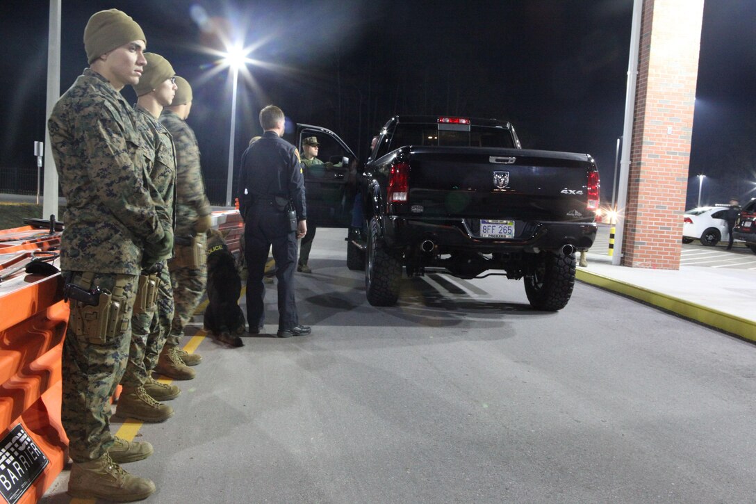 Marines wait for a driver to open all doors to search the vehicle during recent random vehicle checks aboard Marine Corps Base Camp Lejeune. Additional personnel were brought in to maximize the efficiency of the searches along with K-9 and other aspects of the base’s law enforcement arsenal. 