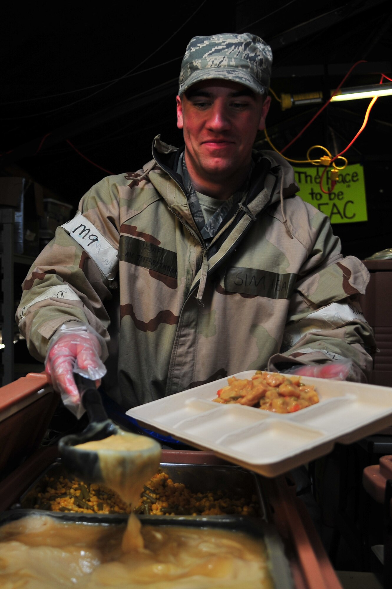 U.S. Air Force Airman 1st Class Jeffrey Taylor, 4th Force Support Squadron Fitness specialist, serves food at the field kitchen during Operational Readiness Inspection CORONET WHITE on Seymour Johnson Air Force Base, N.C., Mar. 8, 2013. Hot meals are prepared during lunch and the midnight meal, and meals ready-to-eat are available for purchase for breakfast and dinner. (U.S Air Force photo/Airman 1st Class Aubrey White/Released)