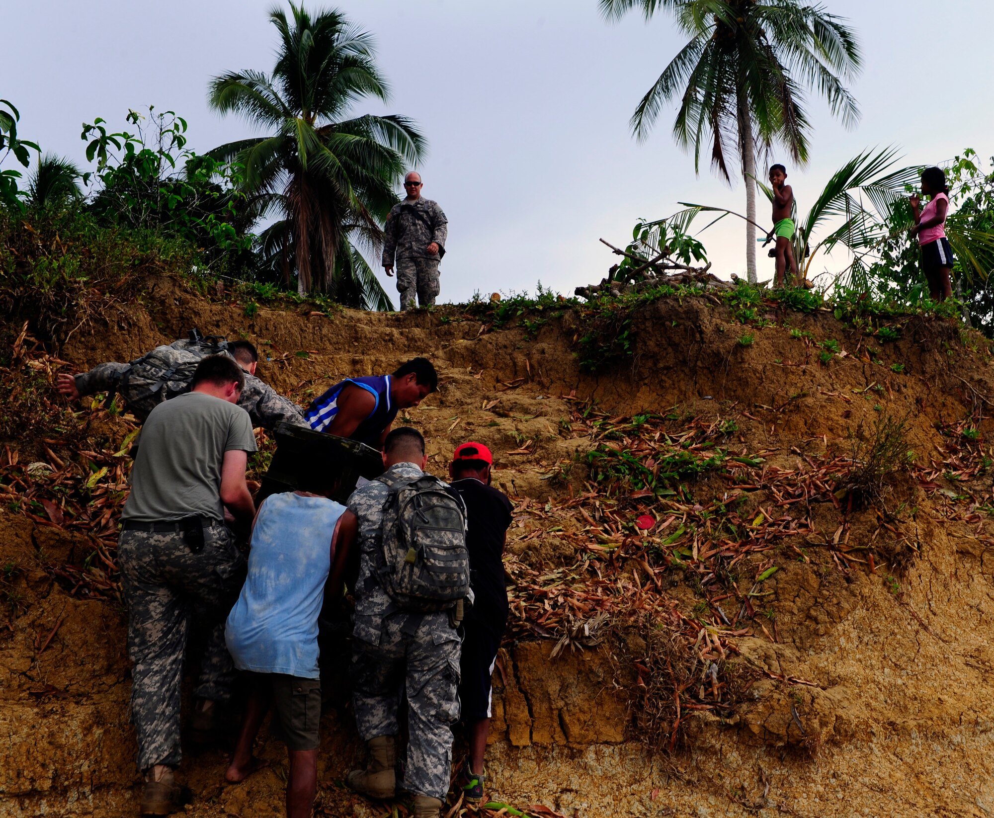 Joint Task Force-Bravo personnel get help from village residents to transport medical supplies to the site of a Medical Readiness Training Exercise in Marraganti, Panama March 1, 2013. Joint Task Force-Bravo partnered with the Panama Ministry of Health, Panama Ministry of Education and Servicio Nacional de Fronteras to exercise their expeditionary medical and mission command capabilities in preparation for future disaster relief events. (U.S. Air Force photo by Capt. Rebecca Heyse)
