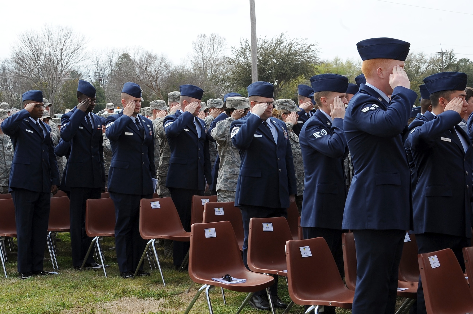Airmen from the 2nd Civil Engineer Squadron Explosive Ordnance Disposal flight and members of Team Barksdale salute during the National Anthem at the dedication ceremony to re-name the Fitness Center to the SrA Bryan Bell Fitness Center on Barksdale Air Force Base, La., March 8. Bell, a member of EOD here, was killed in action in Afghanistan by an improvised explosive device in 2012 while supporting Operation Enduring Freedom. (U.S. Air Force/Staff Sgt. Amber Ashcraft)