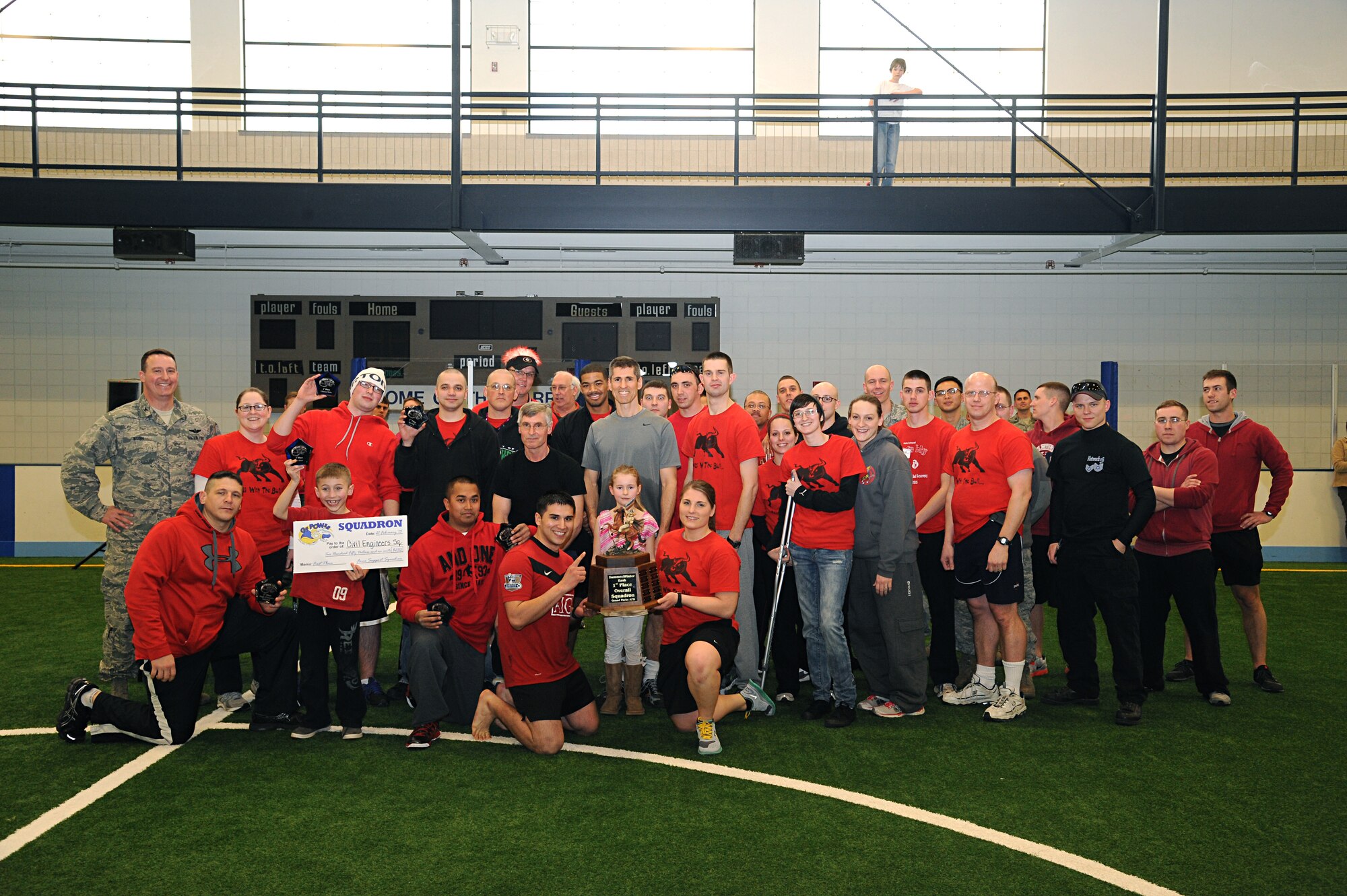 (At left) Col. Tim Bush, 319th Air Base Wing commander, poses for a photo with family members and Airmen from the 319th Civil Engineer Squadron after they took first place in the team category at the 2013 Winter Bash on Feb. 21, 2013, on Grand Forks Air Force Base, N.D. (U.S. Air Force photo/Senior Amber Price)