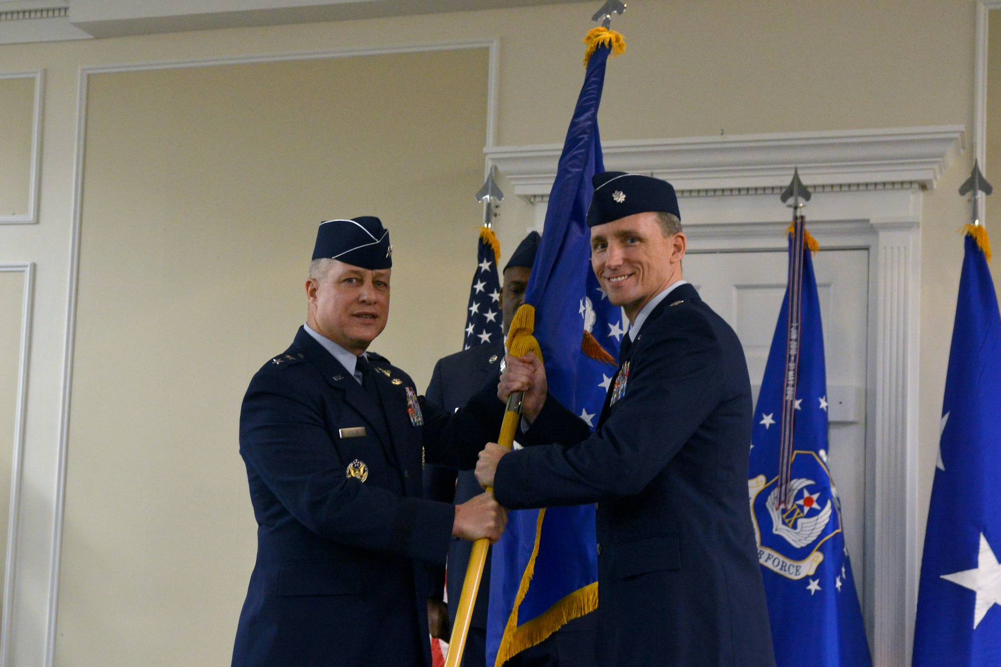 U.S. Air Force Maj. Gen. Lawrence Wells hands the Air Force flag to Lt. Col. Juris Jansons during the 495th Fighter Group activation ceremony, Shaw Air Force Base, S.C., March 8, 2013. Jansons is the first commander of the group and Wells, who is the 9th Air Force commander, presided over the ceremony. An Air Force flag was used to symbolize the group flag because the unit does not currently have a group shield. The 495th Fighter Group will lead its active associate units into the future of Air Force pilot training. The partnerships will allow active-duty, Air National Guard and Air Reserve Component fighter units to share resources, reduce duplications of effort, and ultimately, increase the Air Force’s overall air defense capabilities. (U.S. Air Force photo by Airman 1st Class Ashley L. Gardner/Released)