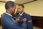 Gen. Edward Rice Jr., Commander of Air Education and Training Command, pins sensor operator wings on Airman 1st Class Abishai's service coat at Abishai's graduation from the 558th Flying Training Squadron's Basic Sensor Operator Course at Joint Base San Antonio-Randolph, Texas March 8, 2013.  Abishai was inspired by the general's story and career and invited him to attend his graduation and pin on his wings.  Rice accepted the invitation and winged several of the Air Force's newest sensor operators; he also served as the speaker for the graduation ceremony.  (U.S. Air Force Photo by Josh Rodriguez)