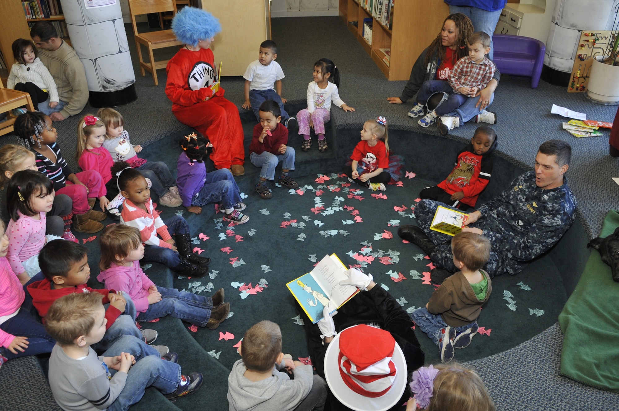 Navy Capt. William Bulis, Joint Base McGuire-Dix-Lakehurst deputy commander, celebrates Read Across America Day March 1, 2013, at Librar-e and Reource Commons at JB MDL, N.J. Children from the joint base community experienced an interactive reading of “One Fish, Two Fish, Red Fish, Blue Fish” by Bulis as Thing 1, Andrea Cramer, and Cat in the Hat, Lt. Col. Gene Mattingly, 87th Mission Support Group deputy commander, acted it out.  (U.S. Air Force photo by Wayne Russell/Released)
