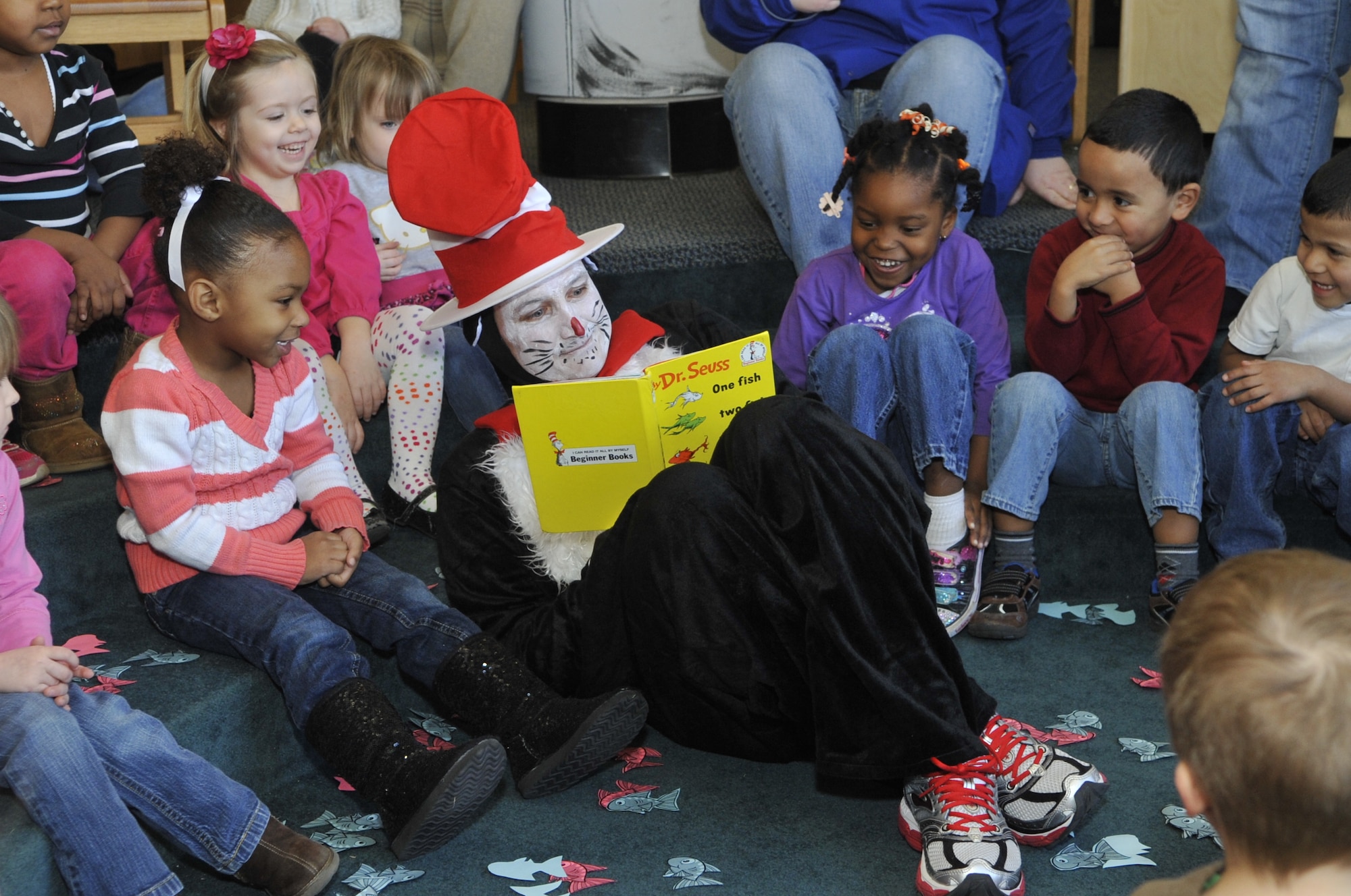 Lt. Col. Gene Mattingly, 87th Mission Support Group deputy commander, dressed as Cat in the Hat, reads “One Fish, Two Fish, Red Fish, Blue Fish” by Dr. Seuss to children of the McGuire Child Development Center March 1, 2013, at the Librar-e Resource Commons for the National Education Association's Read Across America event. Read Across America is an annual reading motivation and awareness program that started March 2, 1998.The day also marks the birthday of Dr. Theodor Geisel, better known to most readers as Dr. Seuss. (U.S. Air Force photo by Wayne Russell/Released)