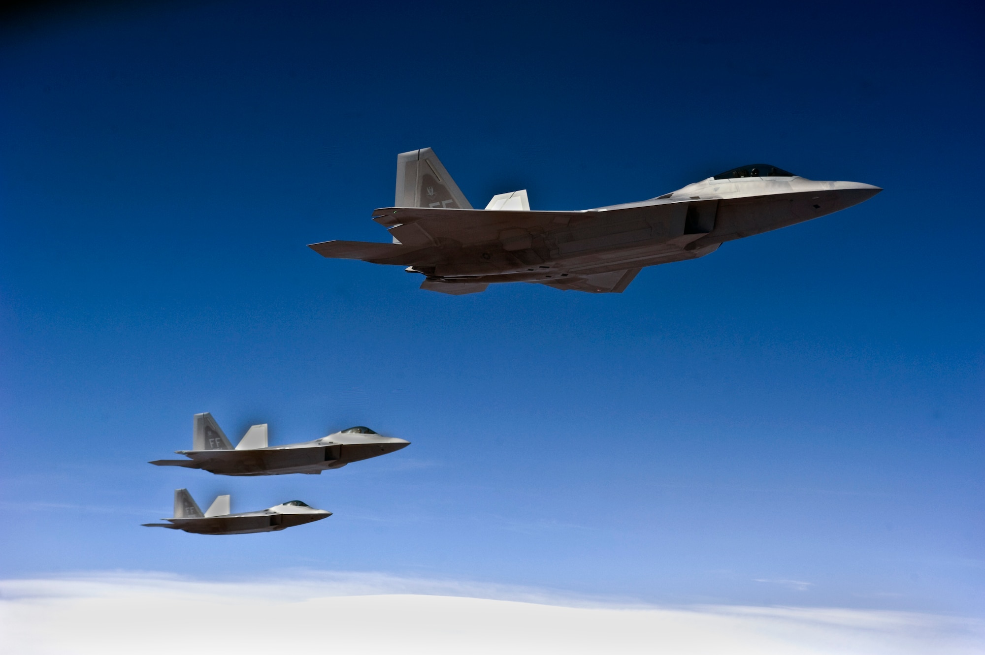 A three-ship formation of F-22 Raptors from the 27th Fighter Squadron out of Langley Air Force Base, Va., participate in Red Flag 13-3 March 5, 2013, fly over the Nevada Test and Training Range. The exercise is hosted by the 414th Combat Training Squadron out of Nellis AFB, Nev. Since combat is no place to train aircrews, the 414th CTS provide a peacetime "battlefield" within which our combat air forces can train. (U.S. Air Force photo by Senior Airman Matthew Lancaster)

