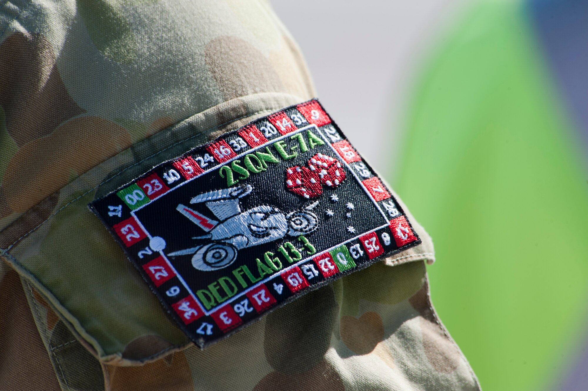 A Royal Australian Air Force airman displays the No. 2 Squadron's Red Flag 13-3 patch at Nellis Air Force Base, Nev., March 27, 2013. The No. 2 Squadron members are participation in Red Flag for the first time. (U.S. Air Force photo by Lawrence Crespo)