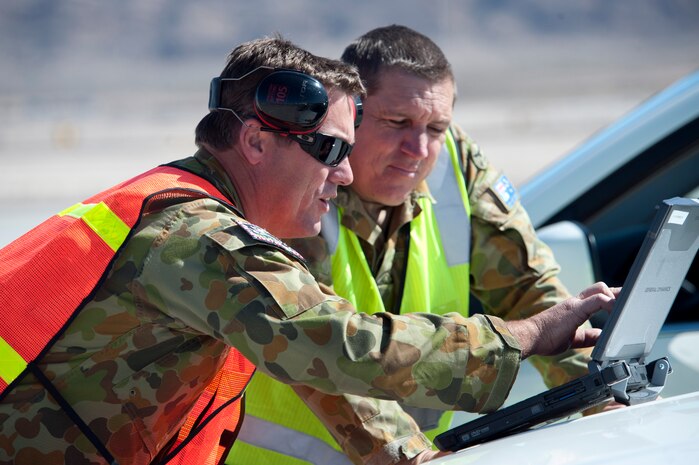 Royal Australian Air Force No. 2 Squadron Flight Sgt. Darrin Cannings and Flight Lt. Scott Harvey, both flight line superintendents, review the E-7A aircraft computerized technical order manual prior to a Red Flag training mission Feb. 27, 2013. Red Flag provides an opportunity for the No. 2 Squadron’s aircrew and maintainers to enhance their operational skills alongside military aircraft from coalition forces. (U.S. Air Force photo by Lawrence Crespo)
