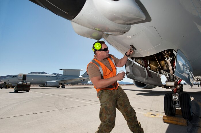 Royal Australian Air Force No. 2 Squadron Leading Aircraftman Doug Ansel, aircraft technician, opens a panel of an E-7A  Wedgetail aircraft prior to a Red Flag training mission Feb. 27, 2013. The RAAF E-7A, an airborne early warning and control aircraft, is participating in Red Flag for the first time. (U.S. Air Force photo by Lawrence Crespo)
