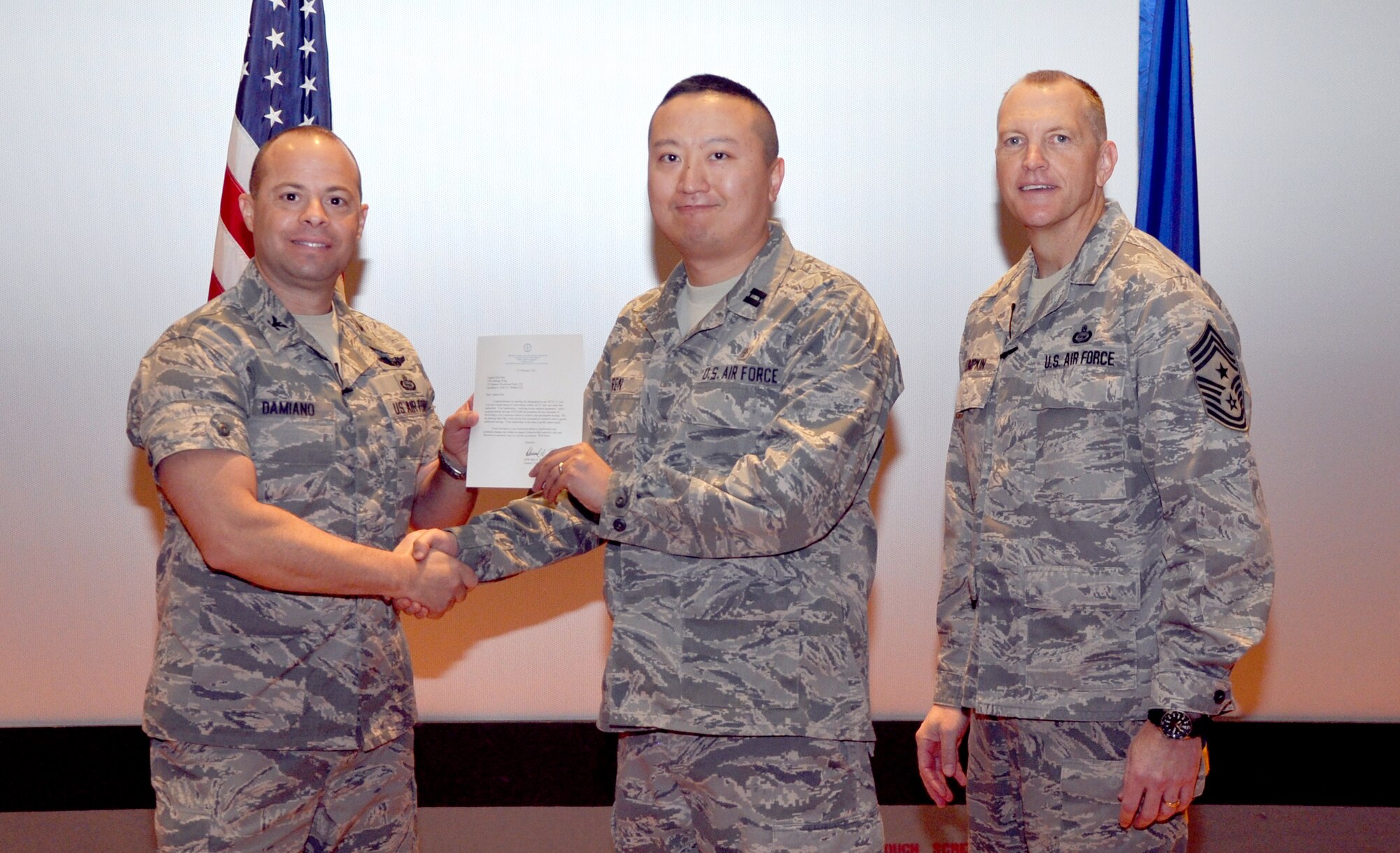 GOODFELLOW AIR FORCE BASE, Texas—Col. Mark Damiano, 17th Training Wing Commander, presents the Air Education and Training Command Cost Conscious Culture Ace award to Capt. Xiao Ren, 17th Medical Group, during the 17th TRW Commander’s Call at the base theater, March 7. (U.S. Air Force photo/1st Lt. Leanne Hedgepeth) 