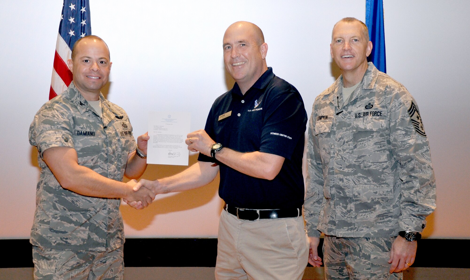 GOODFELLOW AIR FORCE BASE, Texas—Col. Mark Damiano, 17th Training Wing Commander, presents the Air Education and Training Command Cost Conscious Culture Ace award to Martin Littlefield, 17th Force Support Squadron, during the 17th TRW Commander’s Call at the base theater, March 7. (U.S. Air Force photo/1st Lt. Leanne Hedgepeth) 
