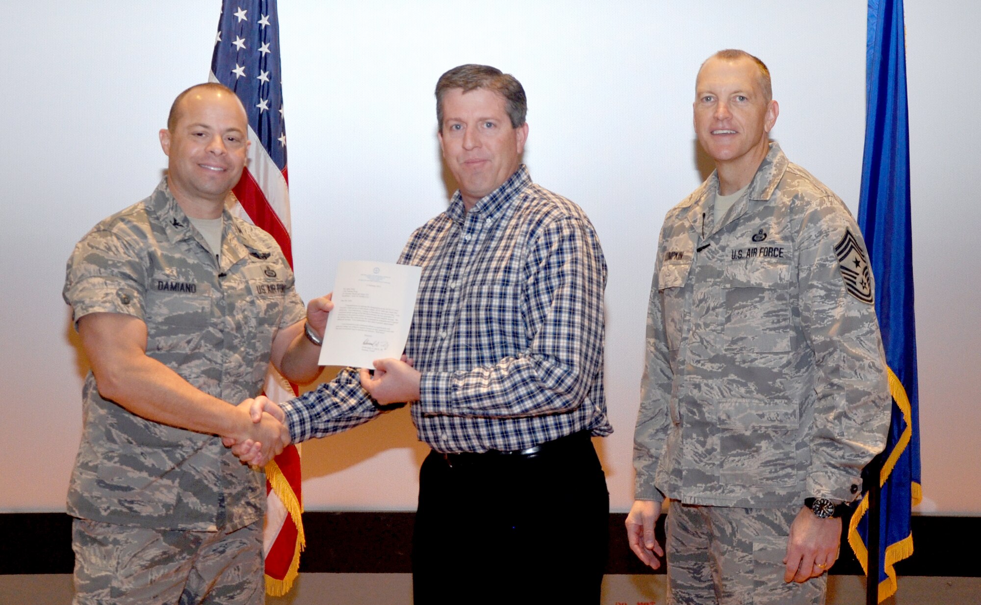 GOODFELLOW AIR FORCE BASE, Texas— Col. Mark Damiano, 17th Training Wing Commander, presents the Air Education and Training Command Cost Conscious Culture Ace award to Jaime Solis, 17th Communications Squadron, during the 17th TRW Commander’s Call at the base theater, March 7. Accepting on his behalf is Kevin Grimes. (U.S. Air Force photo/1st Lt. Leanne Hedgepeth) 