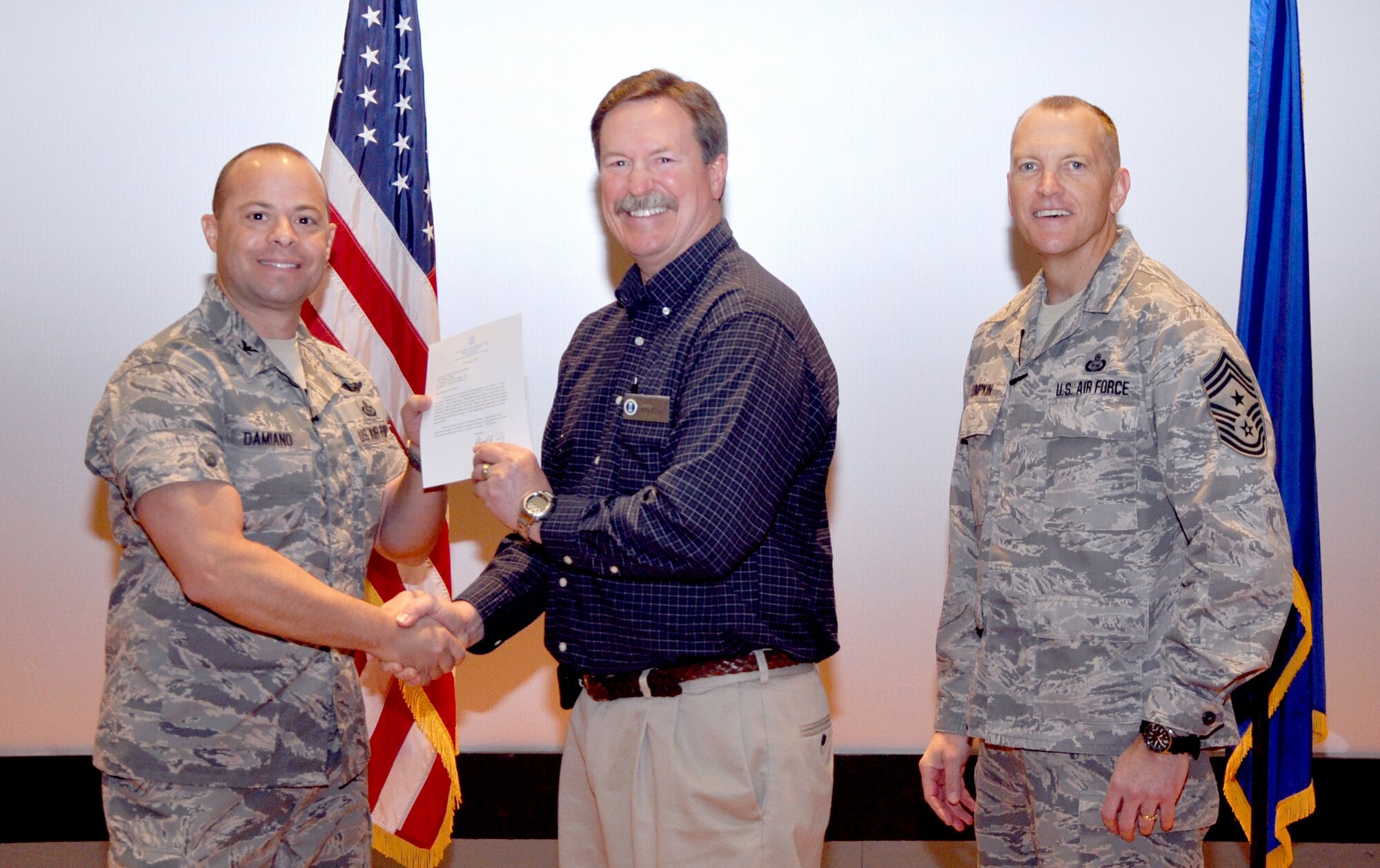 GOODFELLOW AIR FORCE BASE, Texas— Col. Mark Damiano, 17th Training Wing Commander, presents the Air Education and Training Command Cost Conscious Culture Ace award to Tech. Sgt. Jason Kauffung, 17th Communications Squadron, during the 17th TRW Commander’s Call at the base theater, March 7. Accepting on his behalf is Larry Stewart. (U.S. Air Force photo/1st Lt. Leanne Hedgepeth) 