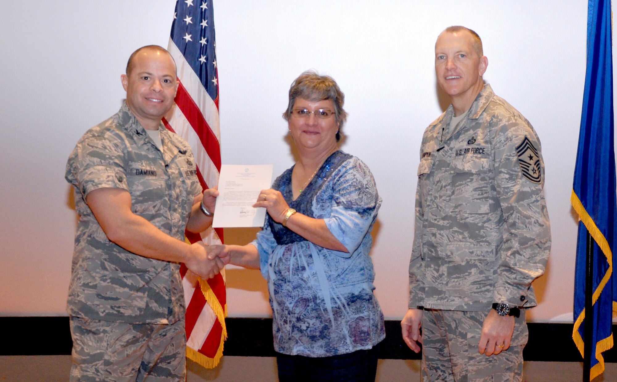GOODFELLOW AIR FORCE BASE, Texas— Col. Mark Damiano, 17th Training Wing Commander, presents the Air Education and Training Command Cost Conscious Culture Ace award to Mary Lumsdon, 17th Civil Engineering Squadron, during the 17th TRW Commander’s Call at the base theater, March 7. (U.S. Air Force photo/1st Lt. Leanne Hedgepeth) 