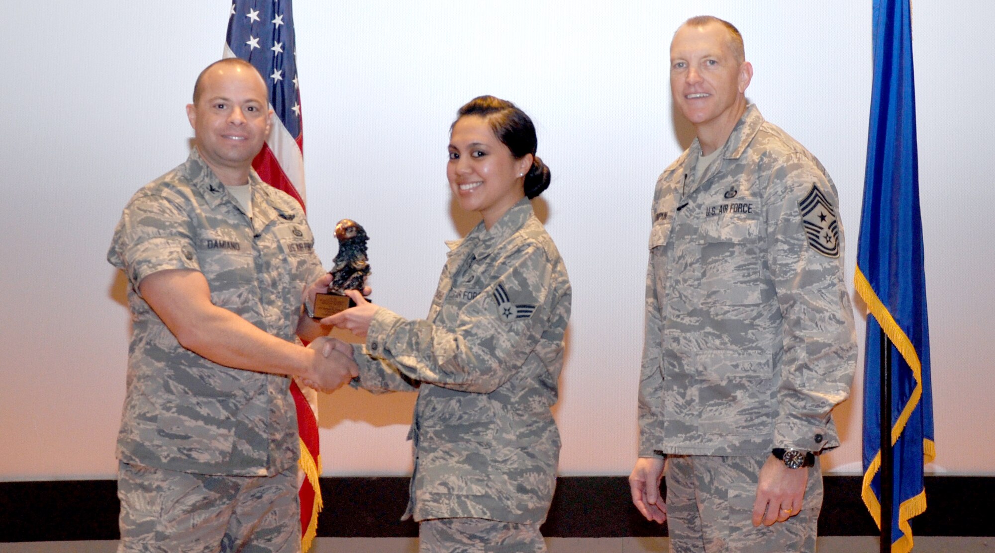 GOODFELLOW AIR FORCE BASE, Texas— Col. Mark Damiano, 17th Training Wing Commander, presents the Air Education and Training Command Financial Management Airman of the Year 2012 award to Senior Airman Jeremiah Camacho, 17th Comptroller Squadron, during the 17th TRW Commander’s Call at the base theater, March 7. Accepting on his behalf is his wife, Senior Airman Julie Camacho. (U.S. Air Force photo/1st Lt. Leanne Hedgepeth) 
