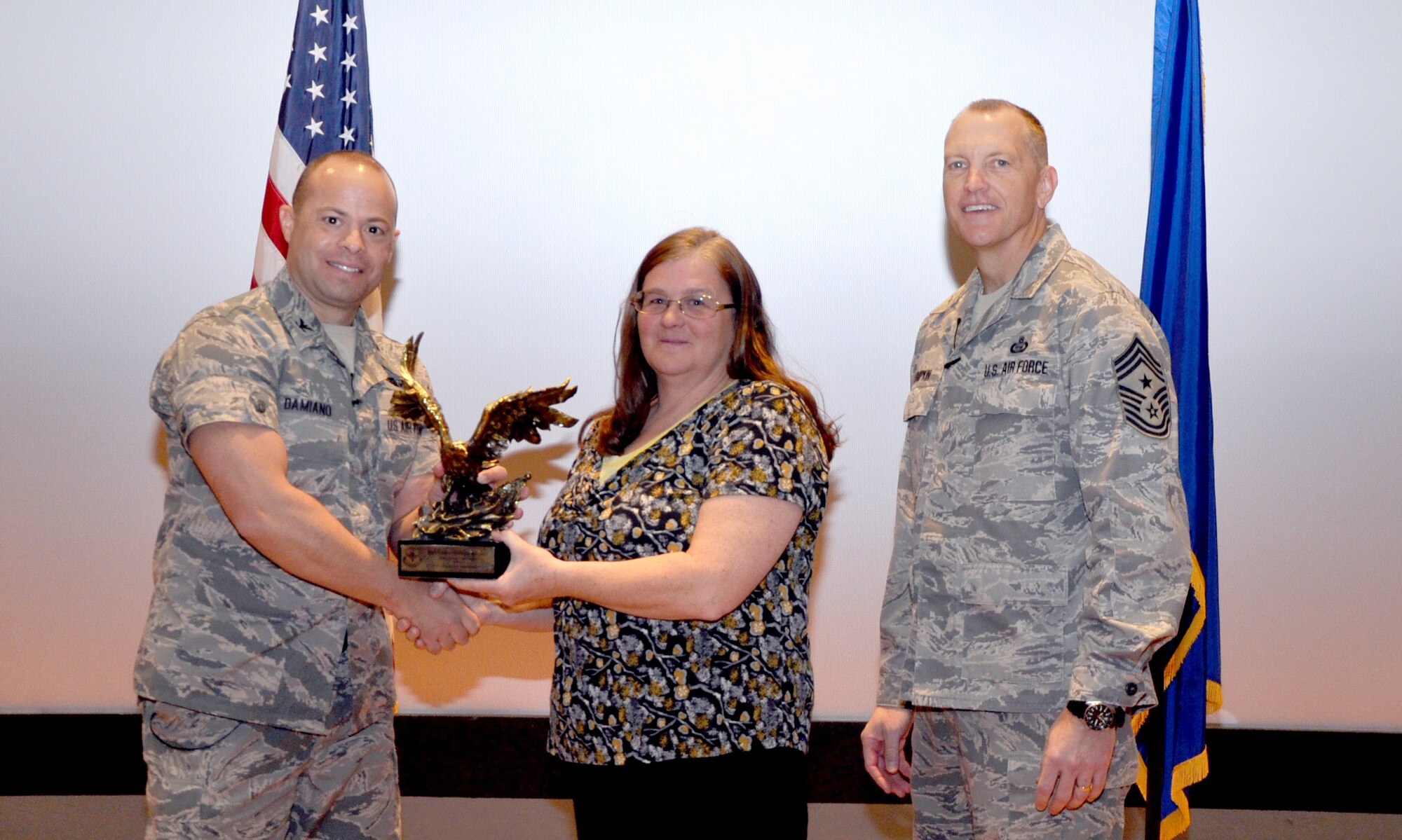 GOODFELLOW AIR FORCE BASE, Texas—Col. Mark Damiano, 17th Training Wing Commander, presents the Outstanding Cyber Surety Airman of the Year award to Senior Airman Christopher Rigney during the 17th TRW Commander’s Call at the base theater, March 7. Accepting on his behalf is Cathy Clark. (U.S. Air Force photo/1st Lt. Leanne Hedgepeth)