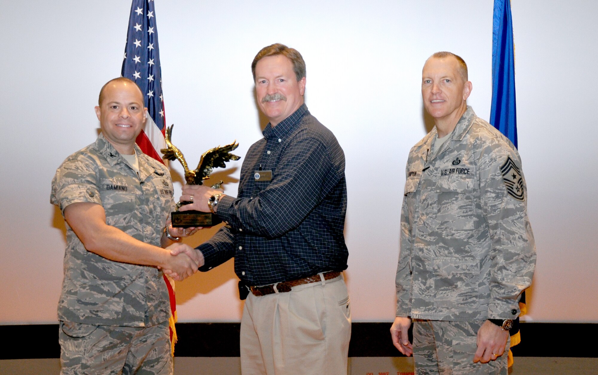 GOODFELLOW AIR FORCE BASE, Texas— Col. Mark Damiano, 17th Training Wing Commander, presents the Air Education and Training Command Outstanding Radio Frequency transmission Systems Noncommissioned Officer of the Year award to Staff Sgt. Daniel Letchworth,  17th Communications Squadron, during the 17th TRW Commander’s Call at the base theater, March 7. Accepting on his behalf is Larry Stewart. (U.S. Air Force photo/1st Lt. Leanne Hedgepeth) 