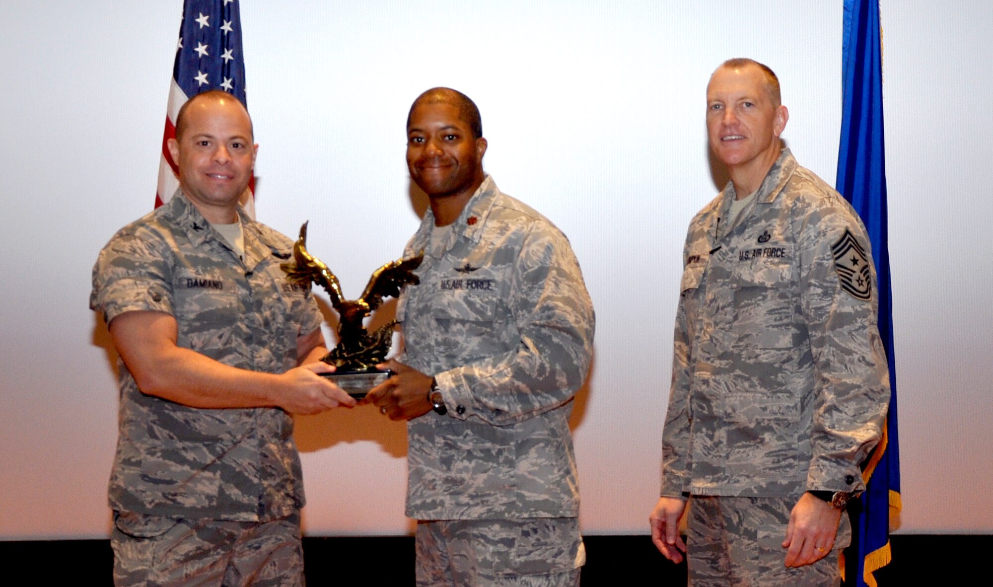 GOODFELLOW AIR FORCE BASE, Texas— Col. Mark Damiano, 17th Training Wing Commander, presents the Air Education and Training Command Outstanding Cyberspace Field Grade Officer of the Year award to Maj. Christopher Robinson,  17th Communications Squadron, during the 17th TRW Commander’s Call at the base theater, March 7. (U.S. Air Force photo/1st Lt. Leanne Hedgepeth) 