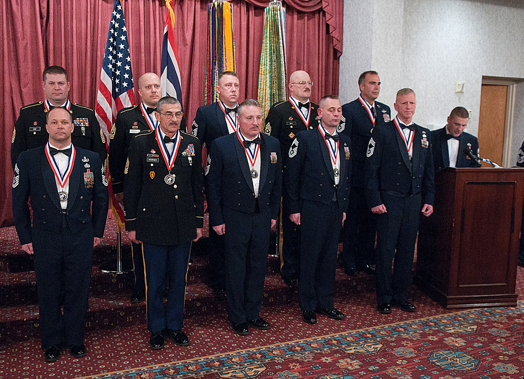 Newly inducted chief master sergeants and sergeants major stand at attention in the Trail’s End Club March 1 as Chief Master Sgt. Michael Garrou, 90th Missile Wing command chief, gives his remarks during the induction ceremony. The induction ceremony paid tribute to those assigned to F. E. Warren Air Force Base, Wyo., the Wyoming Air National Guard and the Wyoming Army National Guard who have been promoted to the rank of E-9.

Inductees:
Chief Master Sgt. Jack Goeken, 187th Airlift Squadron
Chief Master Sgt. Scott Hasert, 153rd Communications Flight
Chief Master Sgt. Leroy Rusk, 153rd Civil Engineer Squadron
Chief Master Sgt. Gary Underwood, 90th Civil Engineer Squadron
Senior Master Sgt. Marc Vogt, 90th Maintenance Group
Chief Master Sgt. Bill Whipple, 153rd Maintenance Group
Sgt. Maj. Mark Beyl, 115th Fires Brigade
Sgt. Maj. Thad Ehde, 94th Troop command
Sgt. Maj. James Shreve, Joint Forces Headquarters
Sgt. Maj. Michael Warner, Headquarters and Headquarters Battery, 2/300th Field Artillery Battalion (U.S. Air Force photo by R.J. Oriez)