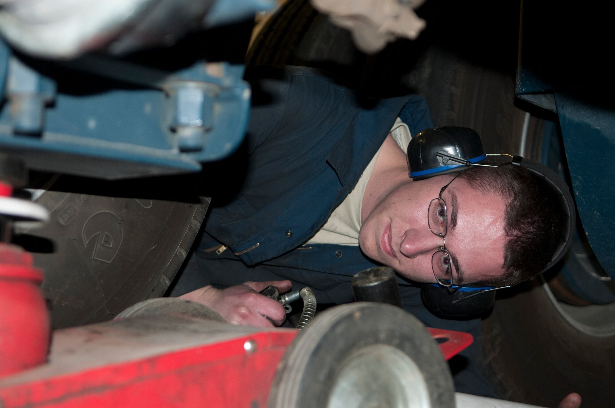 Airman 1st Class William Smith, 90th Logistics Readiness Squadron multipurpose vehicle mechanic, puts a jack beneath a mobile maintenance vehicle in Bldg. 1245 March 4. Smith went on to lift the vehicle with the jack and change the tire. (U.S. Air Force photo by Airman 1st Class Jason Wiese)