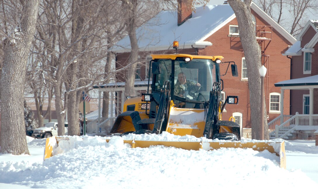 Matt Rix, an airfield clearing operator from the 55th Civil Engineering Squadron, operates a front-end loader with a pusher blade to clear snow from the parking lot of the Base Exchange at Offutt Air Force Base, Neb., Feb. 22. Offutt received eight inches of accumulation with the storm. (U.S. Air Force photo by Delanie Stafford/Released)