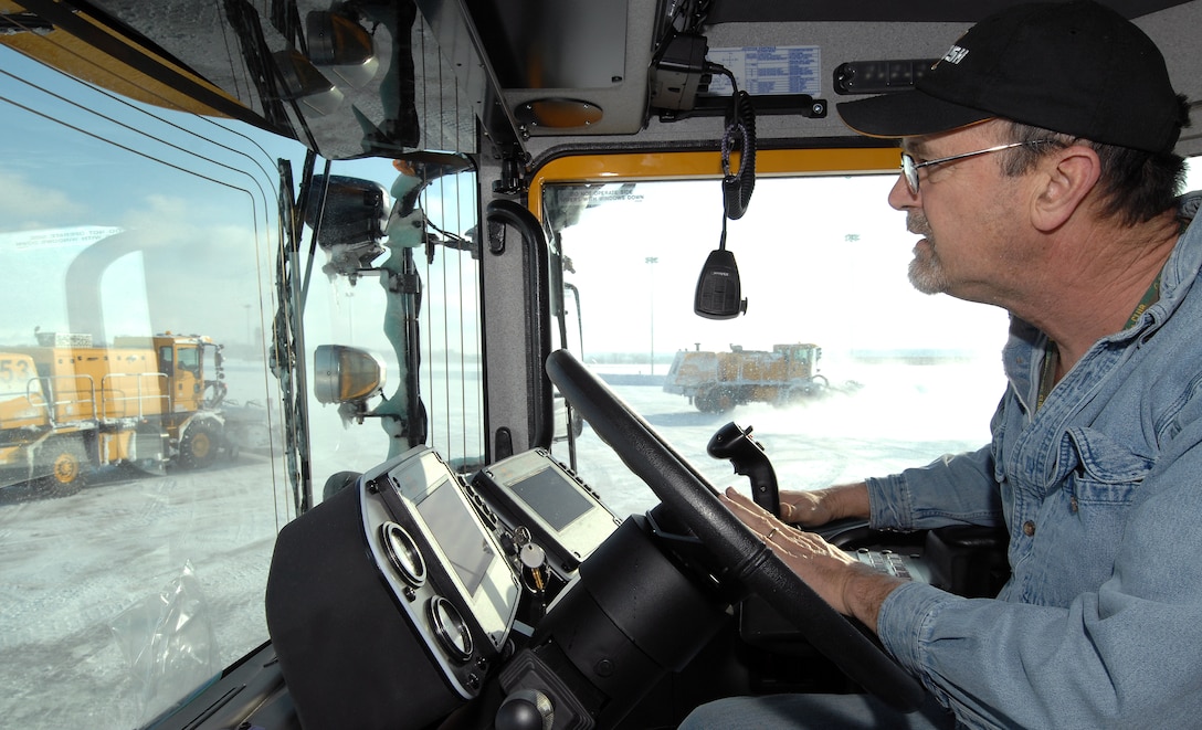 Steve Taylor, an airfield clearing operator from the 55th Civil Engineering Squadron, operates a high-speed broom while sweeping compacted snow from the lower aircraft ramp of Offutt Air Force Base, Neb., Feb. 22. Offutt received eight inches of accumulation with the storm. (U.S. Air Force photo by Delanie Stafford/Released)
