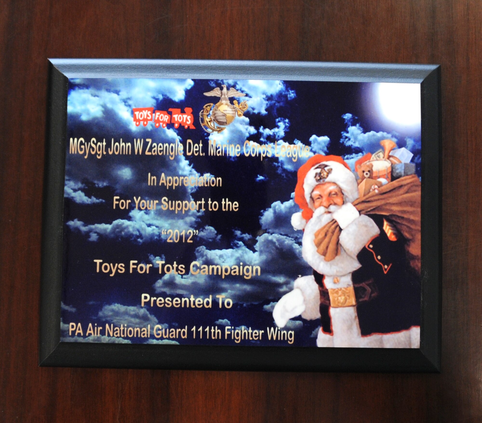Marine Corps League Gunnery Sgt. John W. Zaengle Detachment representatives present a “Toys for Tots” plaque to Col. Howard “Chip” Eissler, 111th Fighter Wing commander, Horsham Air Guard Station, Pa. Air National Guard, on Feb. 14 in appreciation for the hard work and support Wing members provided to their organization during last year’s “Toys for Tots” campaign.