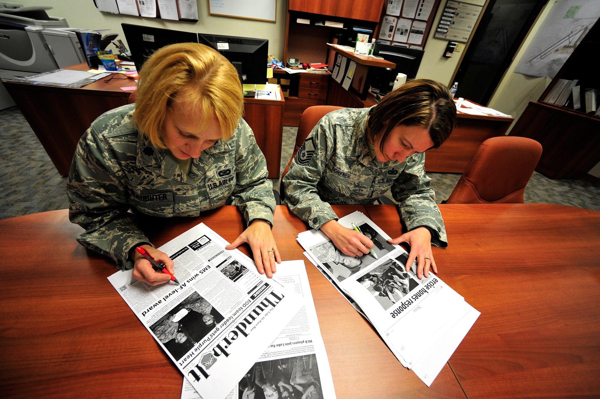 Lt. Col. Holly Slaughter, 56th Fighter Wing Public Affairs acting chief, and Master Sgt. Cindy Dorfner, 56th FW PA section chief, edit the Thunderbolt newspaper Feb. 8 at Luke Air Force Base. PA uses the newspaper, website, Facebook and Twitter to communicate the commander’s message, and the mission of Luke and the Air Force. (U.S. Air Force photo/Staff Sgt. Jason Colbert)