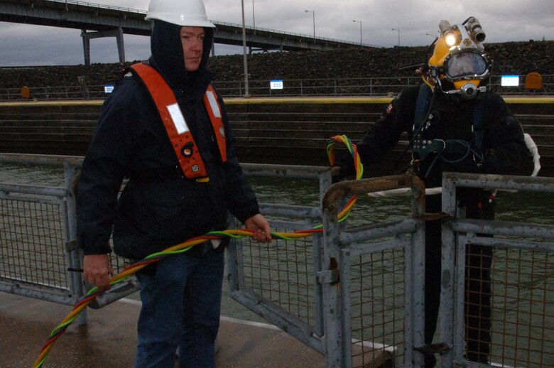 Dive Tender Gary Fleemen, U.S. Army Corps of Engineers Nashville District lock and dam equipment mechanic from Fort Loudoun Lock in Lenoir City, Tenn., monitors the situation as Diver Jeff Neely, also a lock and dam equipment mechanic from Old Hickory Lock in Old Hickory, Tenn., as he ascends into Pickwick Lock in Counce, Tenn., to inspect underwater components ahead of scheduled maintenance later this year. (USACE photo by Lee Roberts)