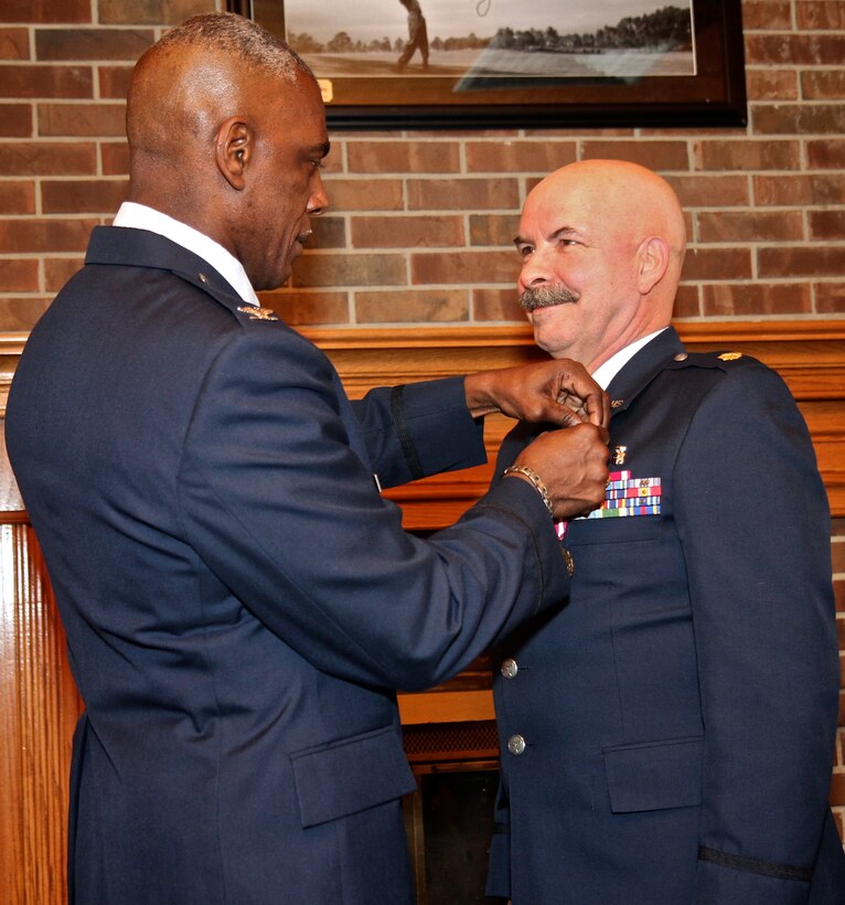Maj. Wiley Roberts recieves the Air Force retirement pin from Col. Arthur Nicholson, 932nd Medical Group Commander.  Roberts officially retired from the Air Force Reserve on March 9, 2013. He served as the flight officer-in-charge (OIC) at the 932nd Aeromedical Staging Squadron.  Roberts served two tours of duty during in support of Operations Iraqi Freedom and Enduring Freedom.  During those deployments, Roberts served as OIC of CASF operations,  assistant chief nurse and chief nurse.  (U.S. Air Force photo/Tech. Sgt. Dan Oliver) 