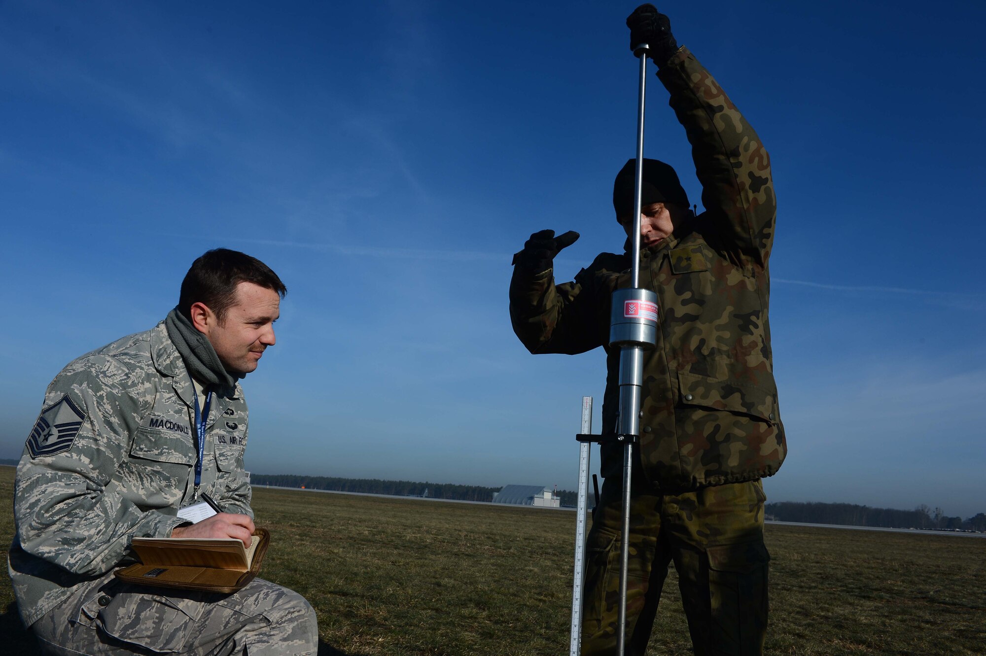 POWIDZ AIR BASE, Poland — Polish Air Force Chief Warrant Officer 2nd Class, 33rd Air Base Infrastructure Company, Powidz Air Base, Poland, tests the soil strength of an unimproved landing zone while U.S. Air Force Master Sgt. Stan MacDonald, an air traffic controller assigned to the 435th Contingency Response Group, Ramstein Air Base, Germany, records the readings prior to a air assault mission conducted by the 37th Airlift Squadron, March 5, 2013.  This is the first official rotation of C-130J Super Hercules aircraft and personnel deployed to Poland in support of Exercise Screaming Eagle V. The exercise, hosted by Aviation Detachment 1, 52nd Operations Group, Lask Air Base, Poland, in support of the Memorandum of Understanding establishing a U.S. presence in Poland on a continuing basis. (U.S. Air Force photo by Tech. Sgt. Kenya Shiloh) (released) 