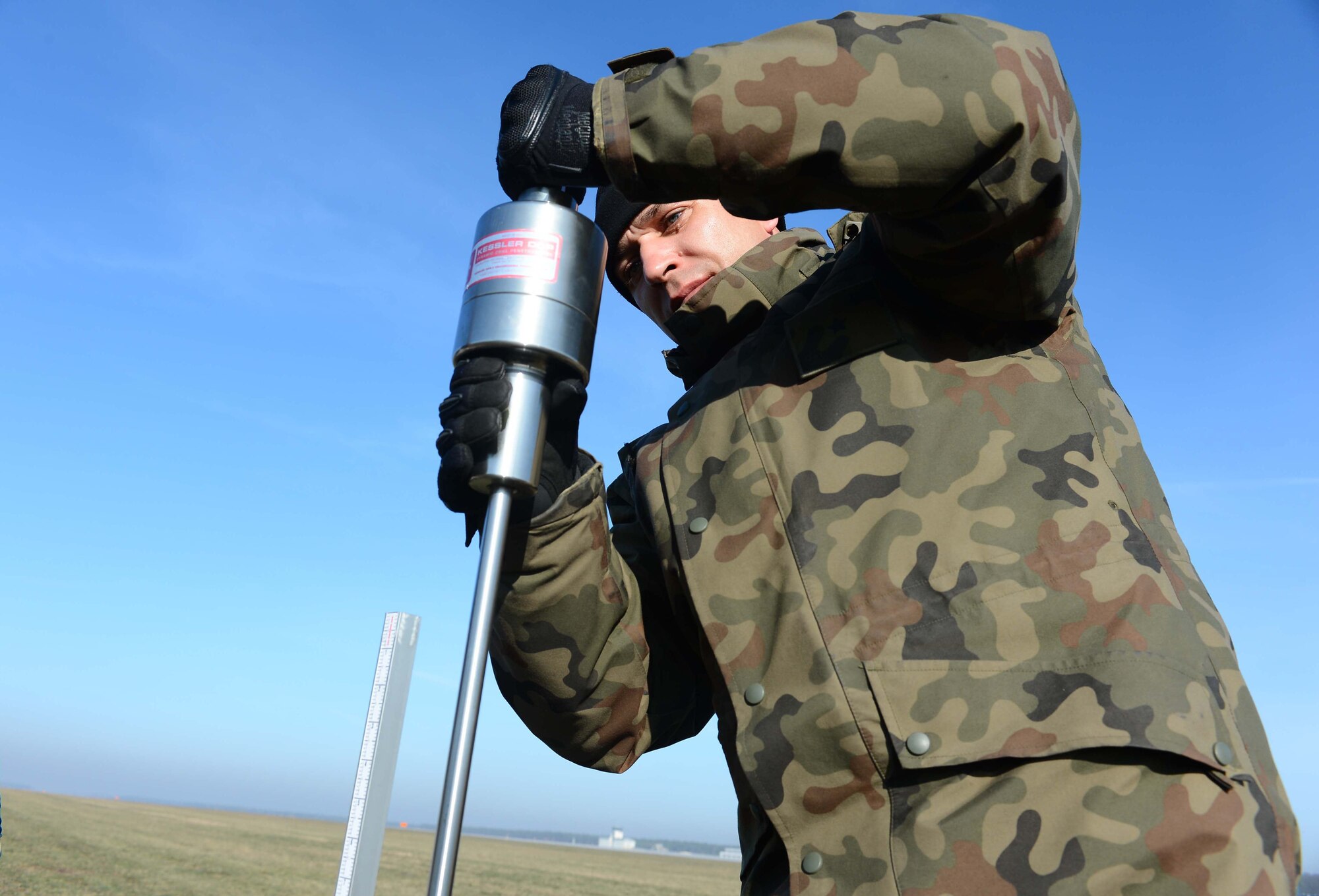POWIDZ AIR BASE, Poland — Polish Warrant Officer 2nd Class Jaroslaw Kozlowski, 33rd Air Base Infrastructure Co., Powidz Air Base, Poland, drops a dynamic cone pentrometer to test the soil strength of an unimproved landing zone prior to a mission conducted by the 37th Airlift Squadron, Ramstein Air Base, Germany, in support of Exercise Screaming Eagle V.  Screaming Eagle V is a bilateral exercise hosted by Aviation Detachment 1, 52nd Operations Group, to promote partnership and air operability with Poland. (U.S. Air Force photo/Tech. Sgt. Kenya Shiloh) (released) 