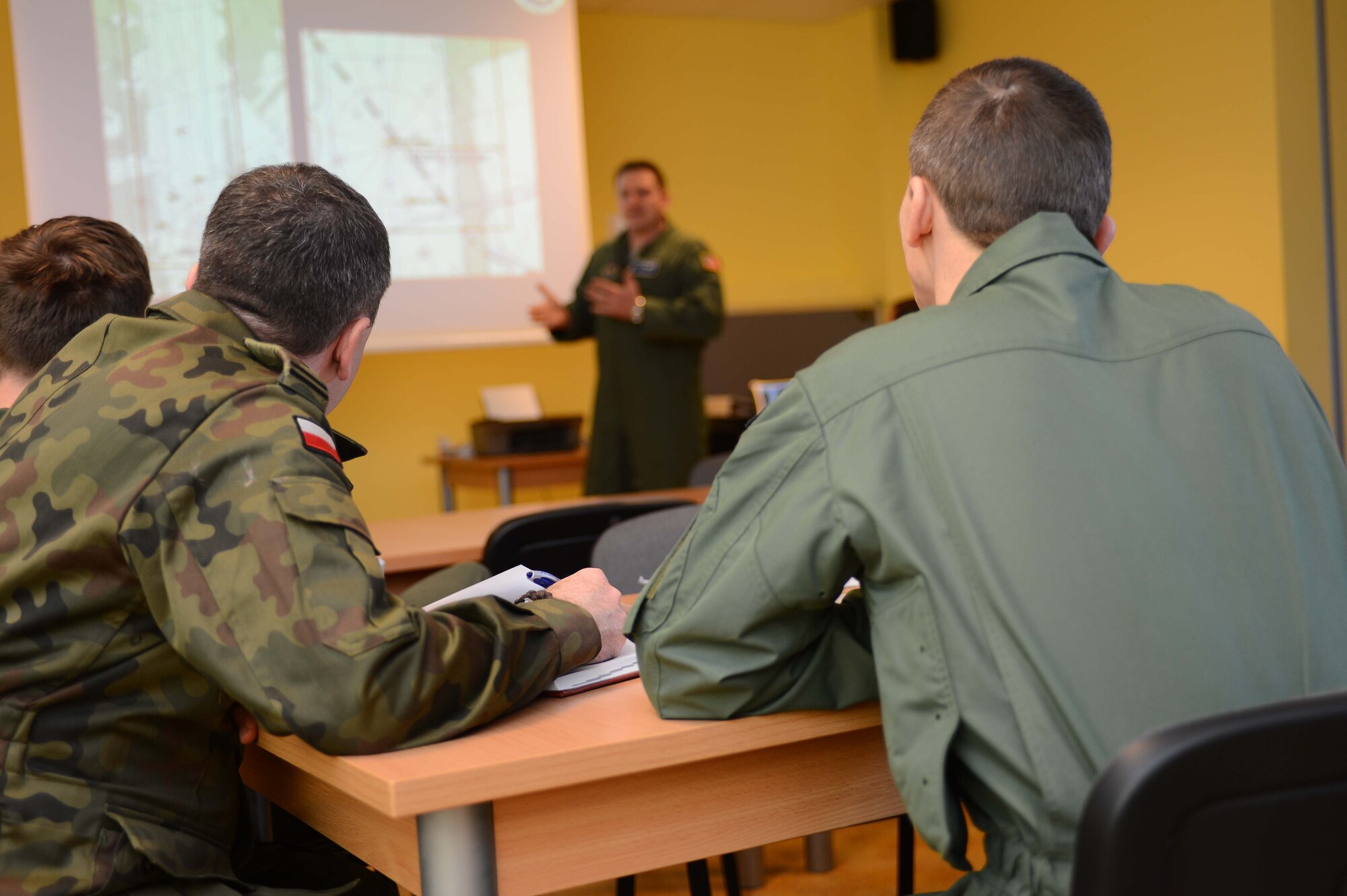 POWIDZ AIR BASE, Poland — Polish air force members assigned to C-130/M-28 Transportation Squadron, Powidz Air Base, Poland, receive a mission brief from Capt. Jarrod Jones, a pilot from the 37th Airlift Squadron, Ramstein Air Base, Germany. The 37th AS is in Poland participating in Exercise Screaming Eagle V, a bilateral exercise hosted by Aviation Detachment 1, 52nd Operations Group, to promote partnership and air operability with Poland. (U.S. Air Force photo/Tech. Sgt. Kenya Shiloh) (released) 