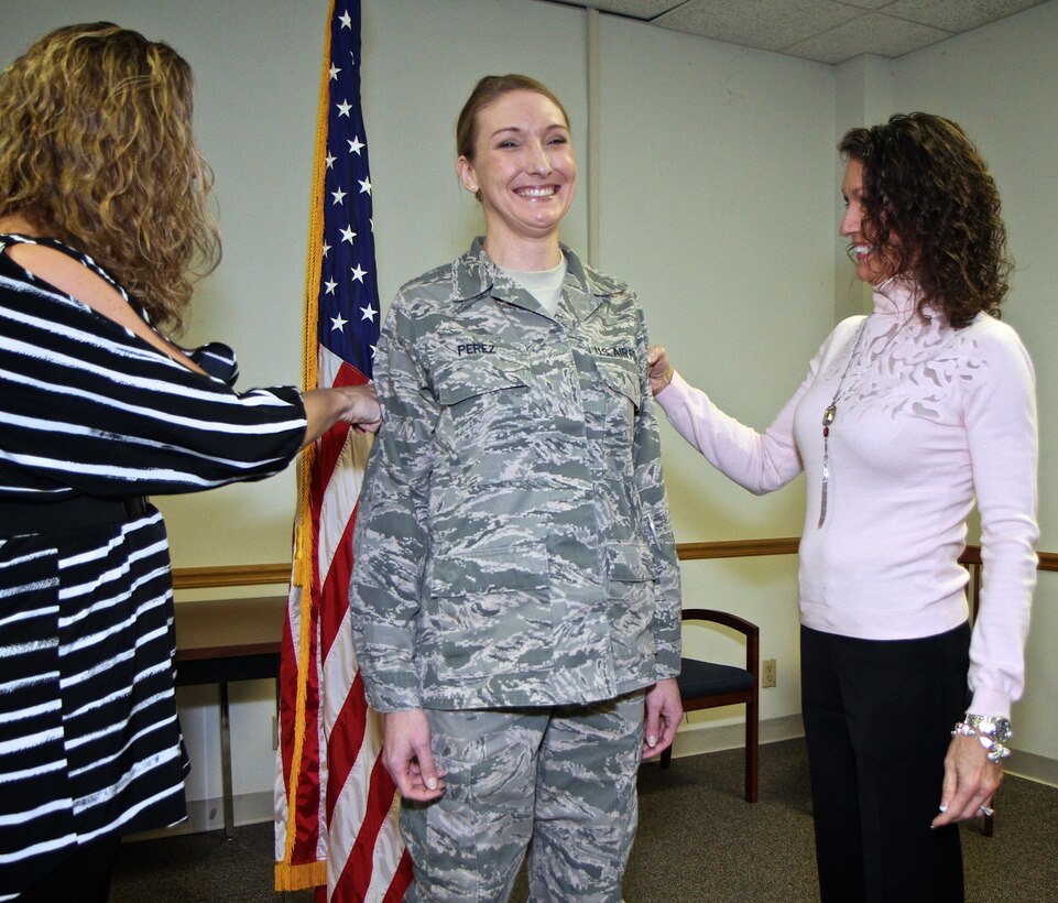 Congratulations are in order!  Recently promoted Master Sgt. Crystal Perez, 932nd Finance Office, is ceremoniously punched in her arms by Perez's mother, Sandra Skarich, right, and her younger sister, Bethanie Dunseith, on Mar. 9th at Scott Air Force Base.  (U.S. Air Force photo/ Tech. Sgt. Christopher Parr)
