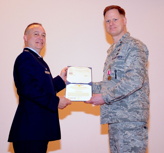 Col. Jeffrey S. Barnett, 442nd Mission Support Group commander, presents the Meritorious Service Medal to Maj. Joe Walter, 442nd Force Support Squadron commander, at the base theater here, March 9. The 442nd Fighter Wing is an A-10 Thunderbolt II Reserve unit at Whiteman Air Force Base, Mo. (U.S. Air Force photo/Senior Airman Wesley C. Wright)