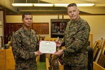 From right, U.S. Marine Brig. Gen. Neil Nelson, 3rd Marine Logistics Group Commanding General and Petty Officer 3rd Class Alexander Ardong, a Corpsman with 3rd Explosive Ordnance Disposal Company, 9th Engineer Support Battalion, pose for a photo together at Camp Hansen, Okinawa, Japan, Feb. 27, 2013. Petty Officer 3rd Class Ardong was presented the Navy and Marine Corps Achievement medal Medal by Brig. Gen. Nelson, for his lifesaving actions after a training mishap in Cambodia. 