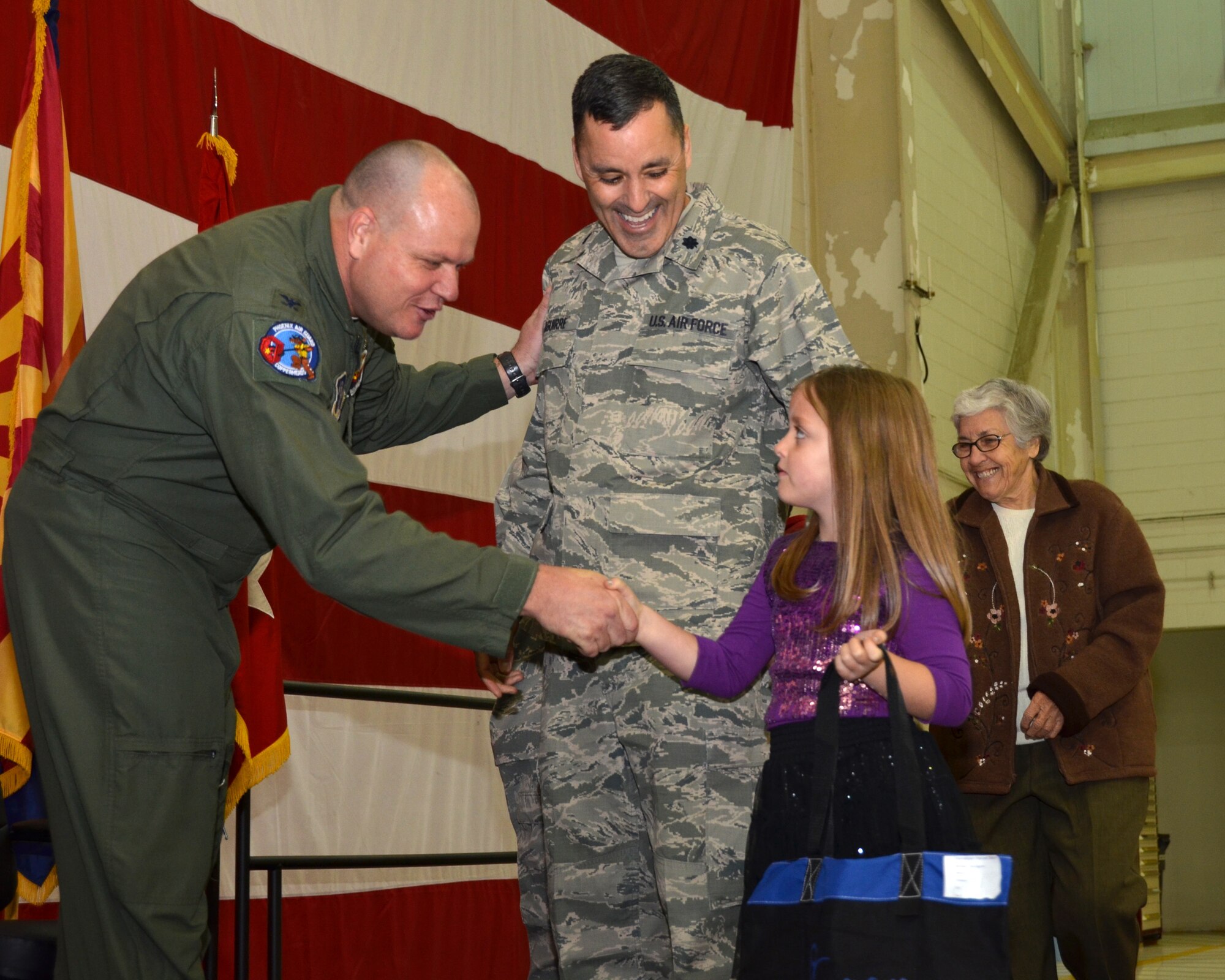 Colonel Gary Brewer, 161st Air Fueling Wing Commander shakes the hand of Alanna Aguirre, daughter of Lt. Col. Paul Aguirre, during the Hometown Hero Salute ceremony, at the 161st ARW, Phoenix, March 9, 2013. Colonel Aguirre and 45 other wing members were recognized for their deployments of more than 30 days for Operations Noble Eagle, Enduring Freedom and Iraqi Freedom and all other contingency operations. This is the fourth Annual event and is unique because it also recognizes Airmen’s families and others who do not wear the uniform, but who sacrifice nonetheless. (U.S. Air Force photo by Senior Airman Rashaunda Williams/Released)