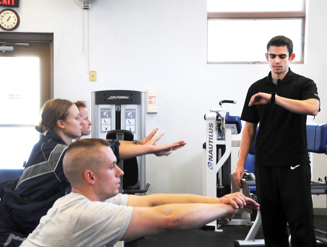 Mike DeRosa (right), the 193rd Special Operation Wing’s new health and fitness specialist, helps unit physical training leaders demonstrate squats during the resistance training portion of a fitness video that is being used at mandatory group fitness sessions. 