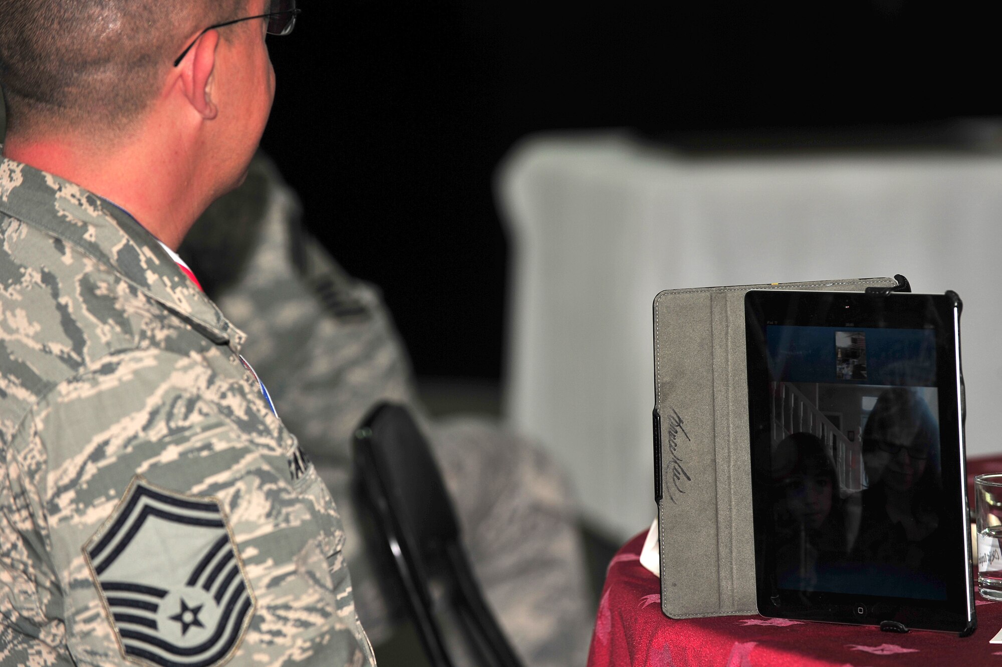 U.S. Air Force Senior Master Sgt. Jay A. Banghart, 380th Expeditionary Aircraft Maintenance Squadron KC-10 Extender aircraft maintenance unit superintendent, Skypes with his family during the Chief Master Sergeant Induction Ceremony in his honor at an undisclosed location in Southwest Asia Mar. 1, 2013. Banghart's wife, Jill, and their children, Owen, Gabby and Claire, were able to attend the entire ceremony via Skype. Banghart will pin on the highest enlisted rank on April 1, 2013. (U.S. Air Force photo by Tech. Sgt. Christina M. Styer/Released)