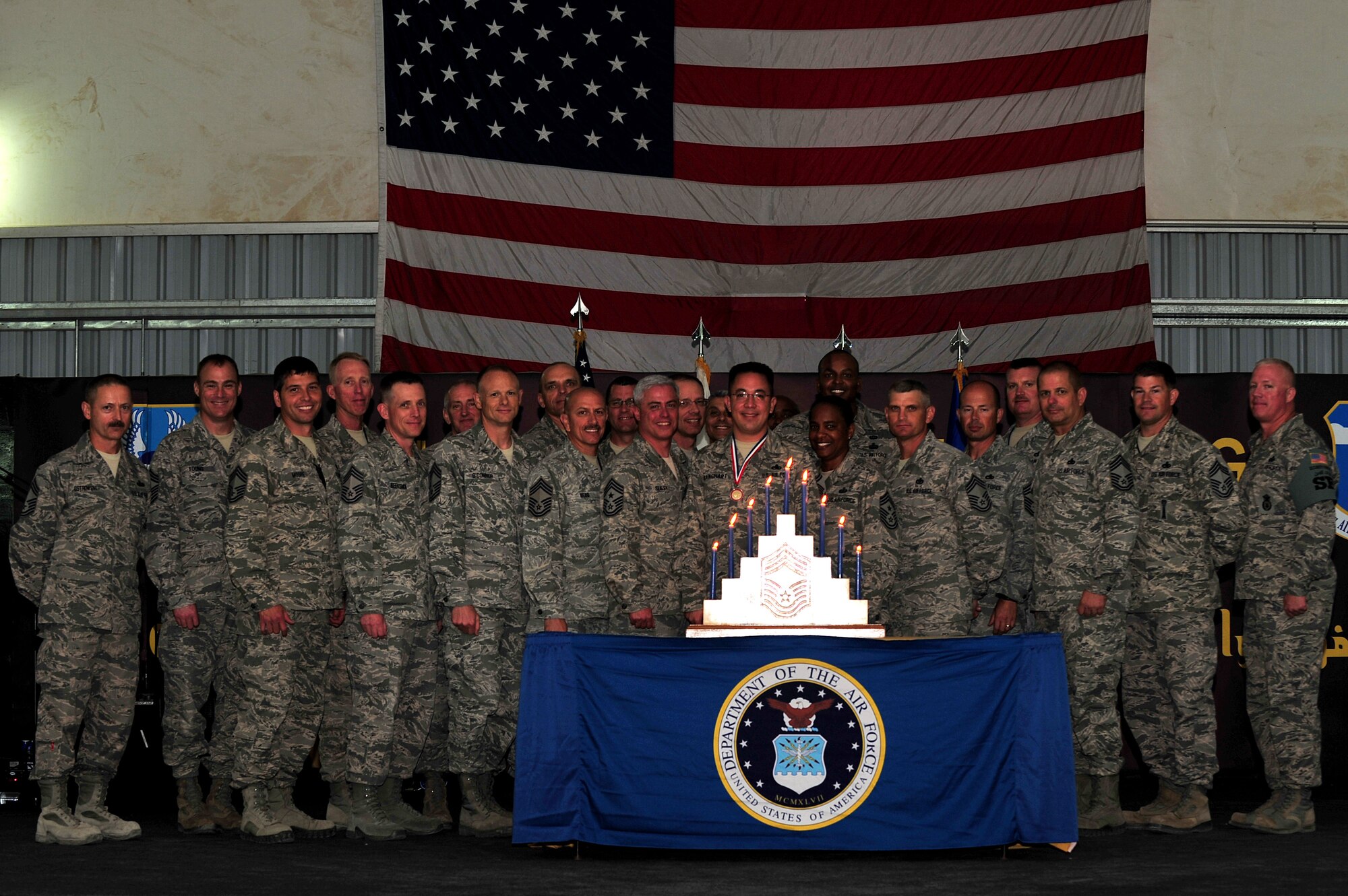 U.S. Air Force Chief Master Sgt. Robert L. Sealey, United States Air Forces Central Command command chief and the 380th Air Expeditionary Wing Chief's Group pose for a group photo with Senior Master Sgt. Jay A. Banghart, 380th Expeditionary Aircraft Maintenance Squadron KC-10 Extender aircraft maintenance unit superintendent, during the Chief Master Sergeant Induction Ceremony at an undisclosed location in Southwest Asia Mar. 1, 2013. The induction ceremony is an Air Force tradition that recognizes the 1 percent of the enlisted force who are selected for advancement to chief master sergeant. Banghart will pin on the highest enlisted rank on April 1, 2013. (U.S. Air Force photo by Tech. Sgt. Christina M. Styer/Released)