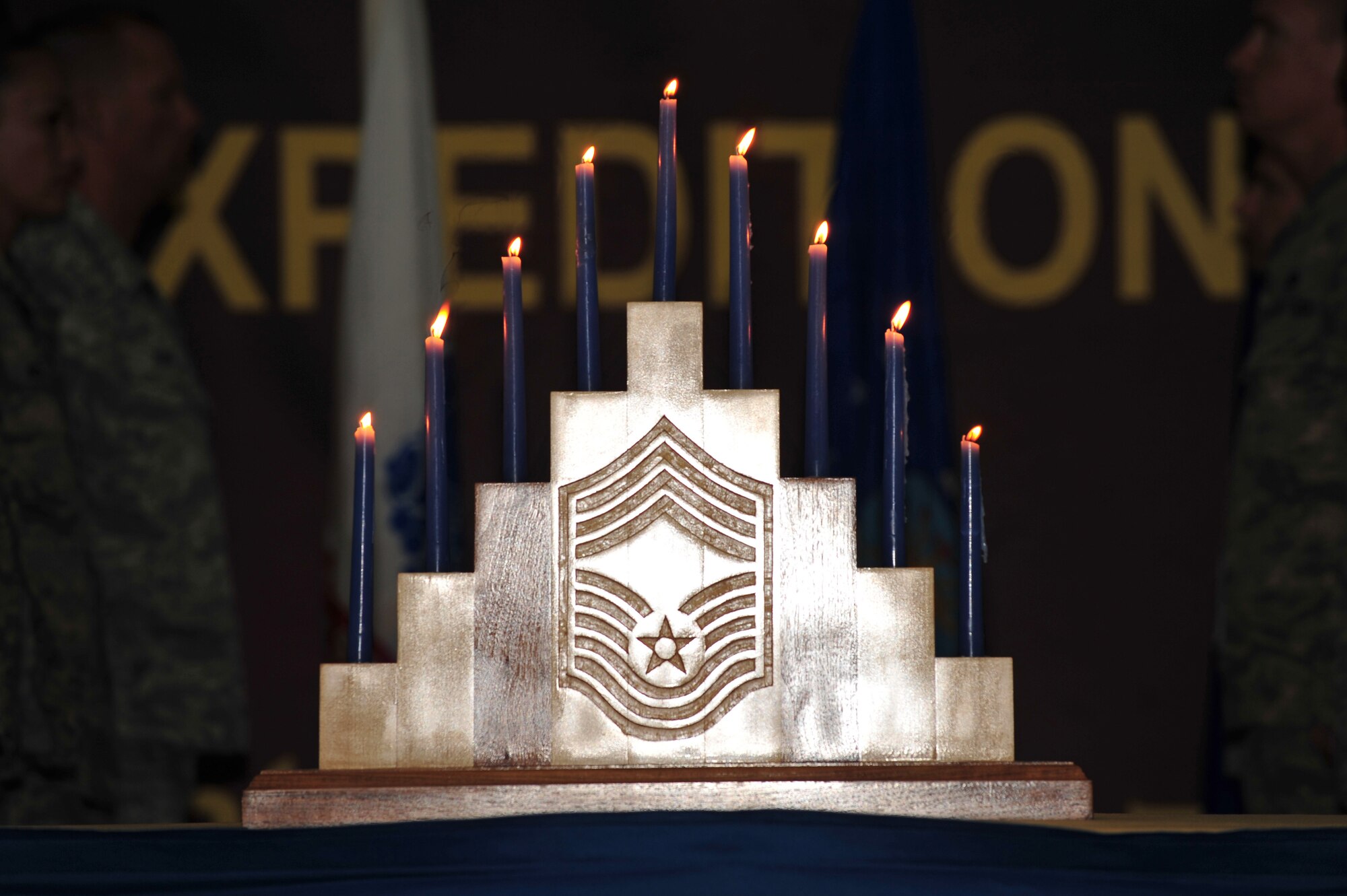 The nine candles symbolically representing each enlisted grade in the Air Force are lit during the Chief Master Sergeant Induction Ceremony at an undisclosed location in Southwest Asia Mar. 1, 2013. The induction ceremony honored Senior Master Sgt. Jay A. Banghart, 380th Expeditionary Aircraft Maintenance Squadron KC-10 Extender aircraft maintenance unit superintendent, who will pin on the highest enlisted rank on April 1, 2013. (U.S. Air Force photo by Tech. Sgt. Christina M. Styer/Released)