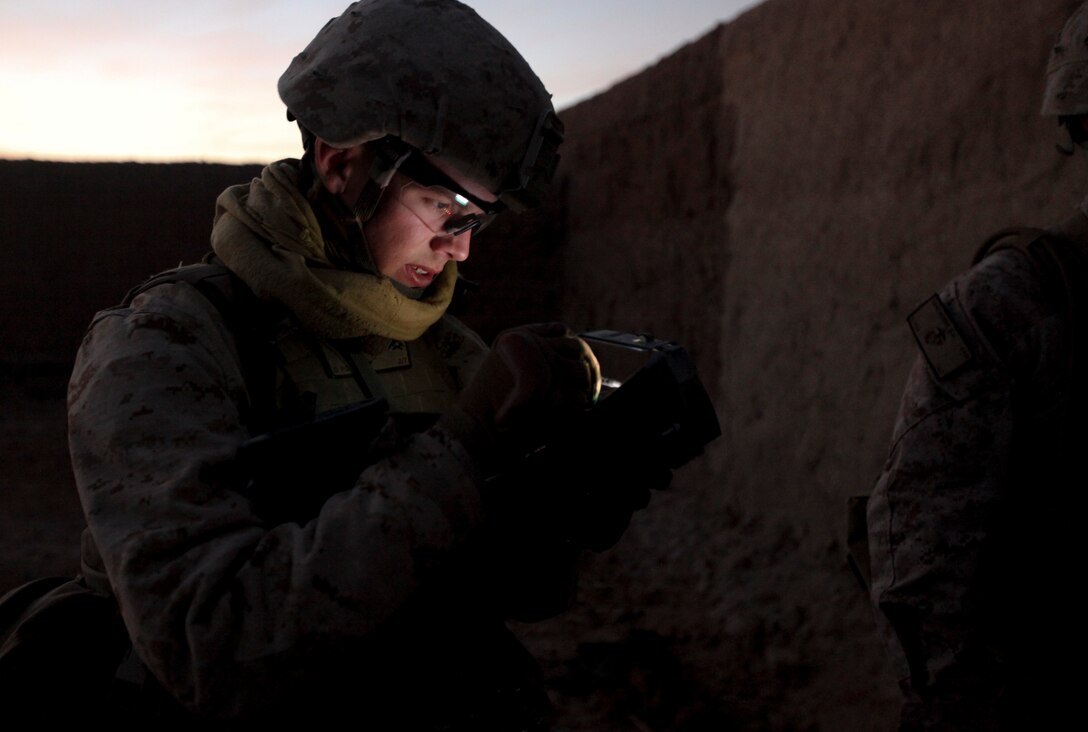 Lance Cpl. Kevin Romero gathers information from suspected insurgents and inputs the information into the unit's SEEK machine. The SEEK is a biometrics machine that allows units to identify known insurgents through the use of fingerprinting. (Photo by Sgt. Bobby J. Yarbrough)