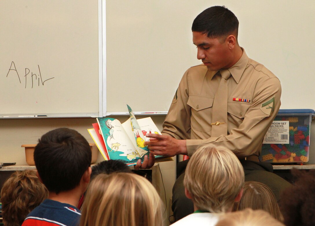 Lance Cpl. Abisai Ochoa, unmanned aerial vehicle operator, Marine Unmanned Aerial Vehicle Squadron 3, reads a book to 1st graders at Joshua Tree Elementary March 1, 2013. Marines with VMU-3 read to the students during National Read Across America Day, an observance in the United States held on the school day close to Dr. Seuss' birthday.
